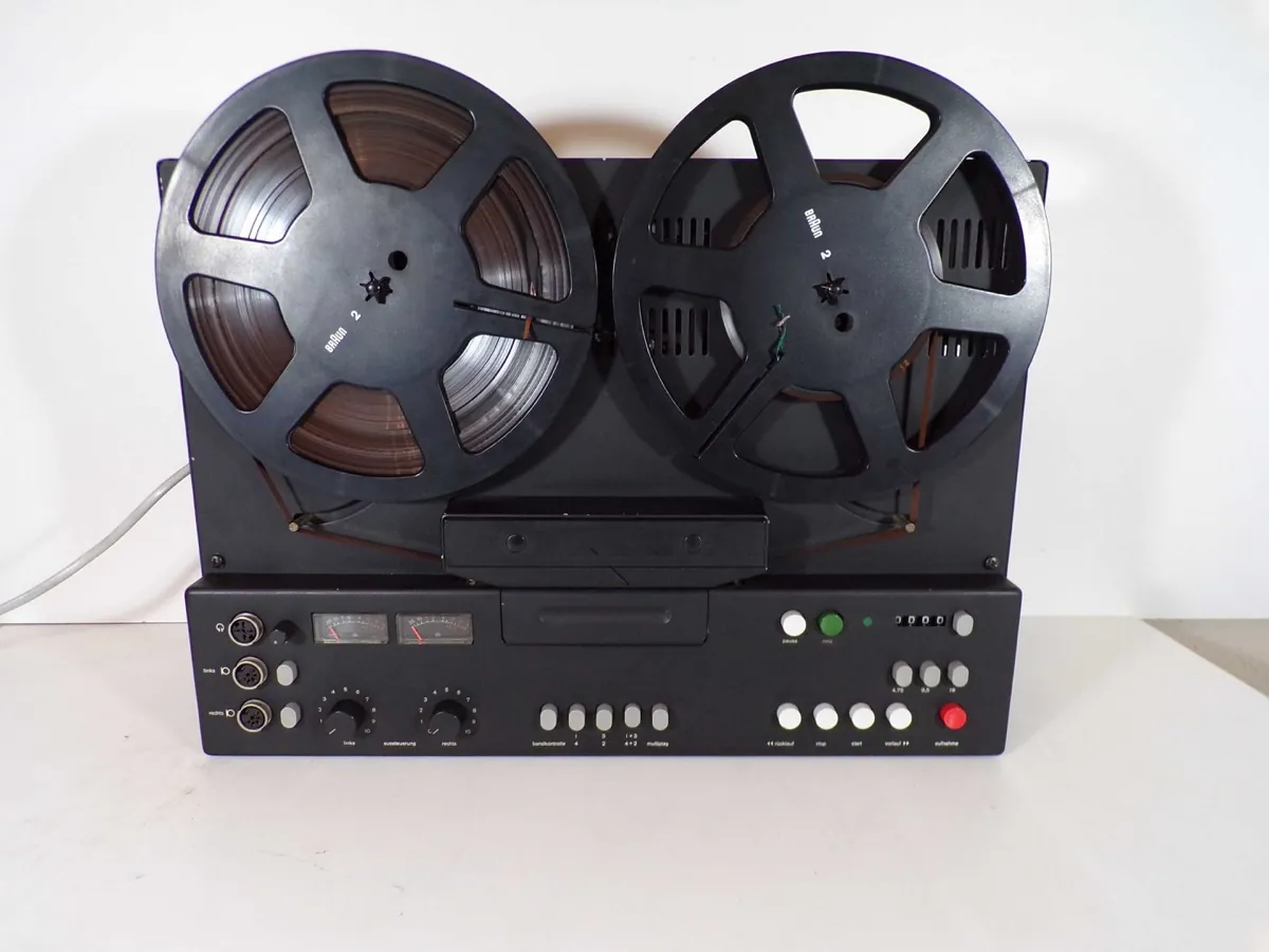 A Braun TG 1000 reel-to-reel tape recorder, two black reels above a grey control panel whose only coloured key is red.